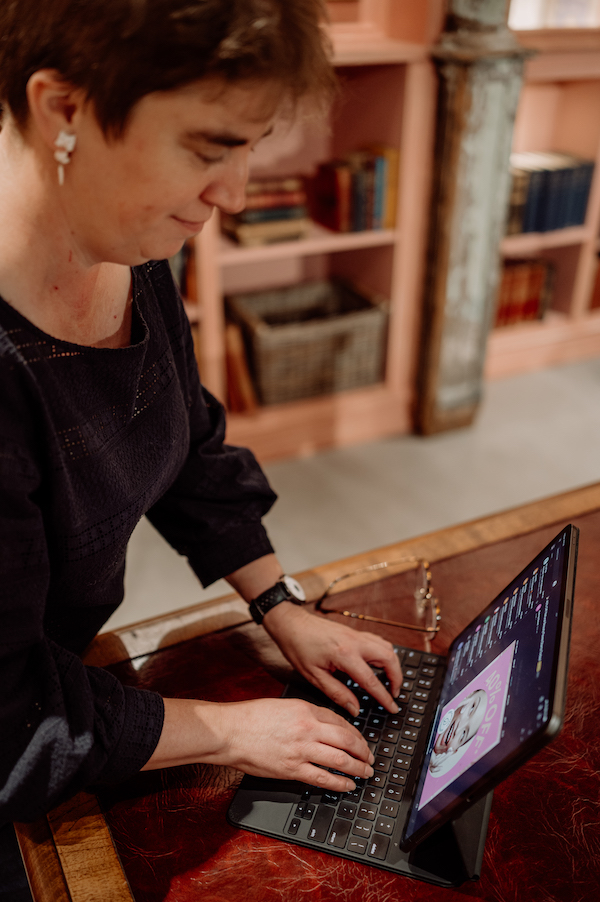 Image of Rachel Amies typing on a keyboard that's connected to her iPad. There's a bookcase in the background. Image is being used on Crazy Digital Creative's blog marketing strategy service page.